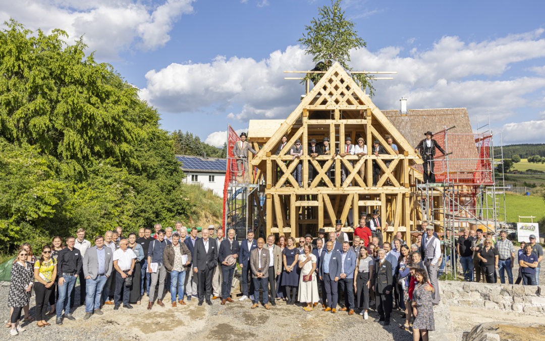 Tesaři v tradičním oděvu oslavují dokončení hrubé stavby v Naturdorfu Bärnau